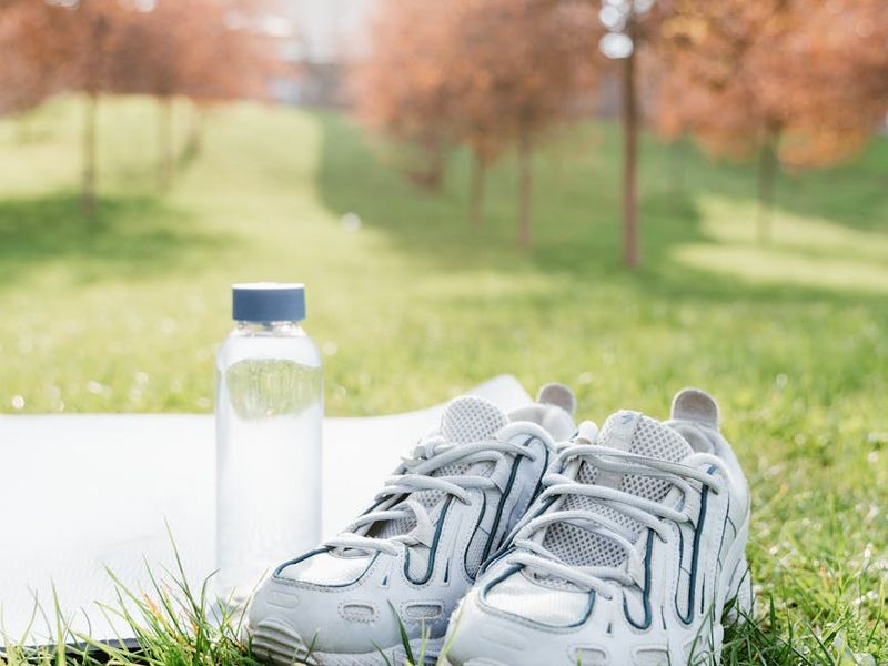 Athletic shoes and water bottle on a clean floor
